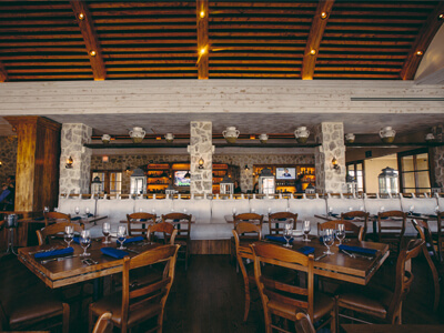 served wooden tables in front of a bar