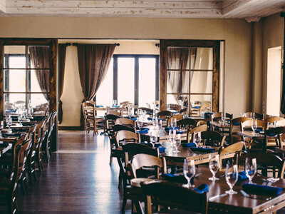 tables served with blue cloth napkins, wine glasses and silverwear